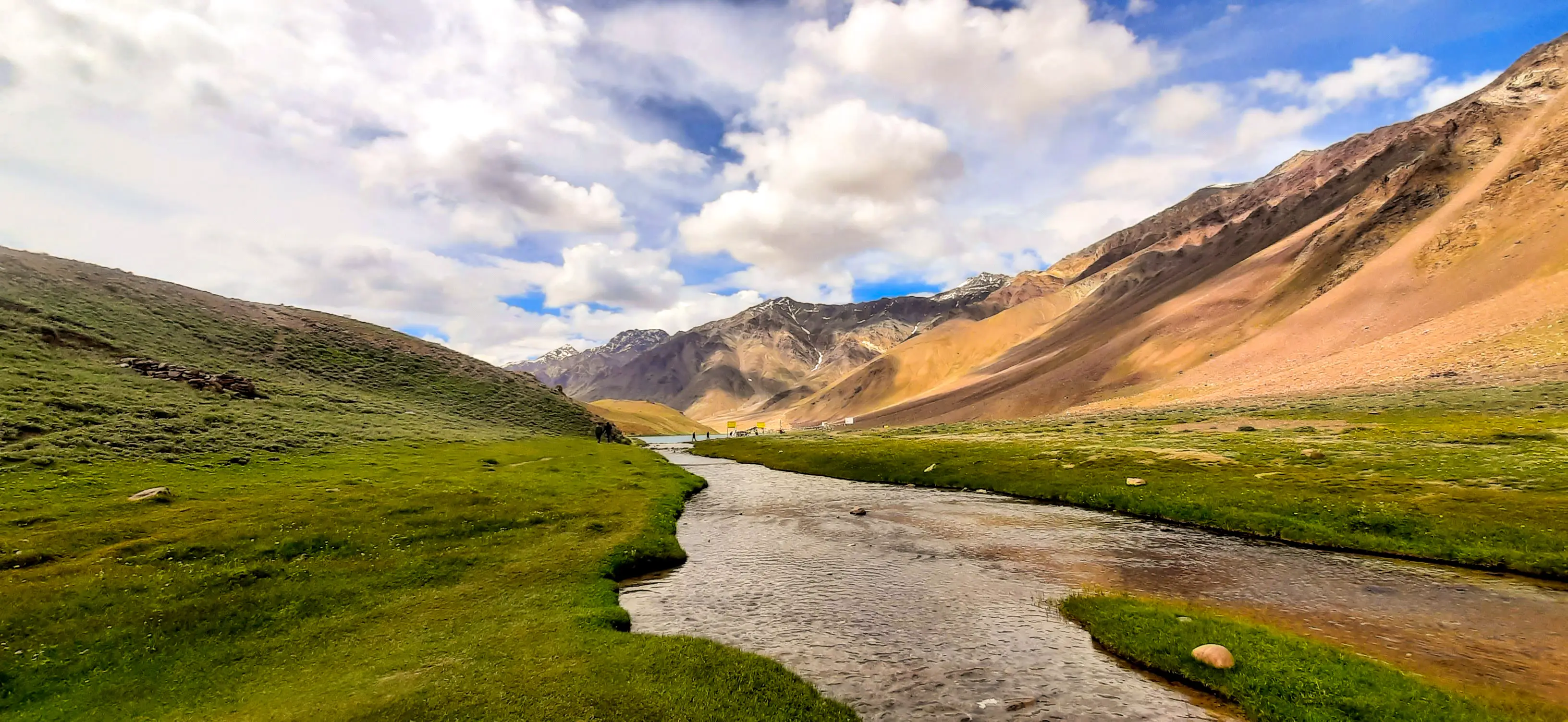 A river curves gently through a green valley not forcing direction, only suggesting it. Walking begins here, guided by instinct rather than certainty.