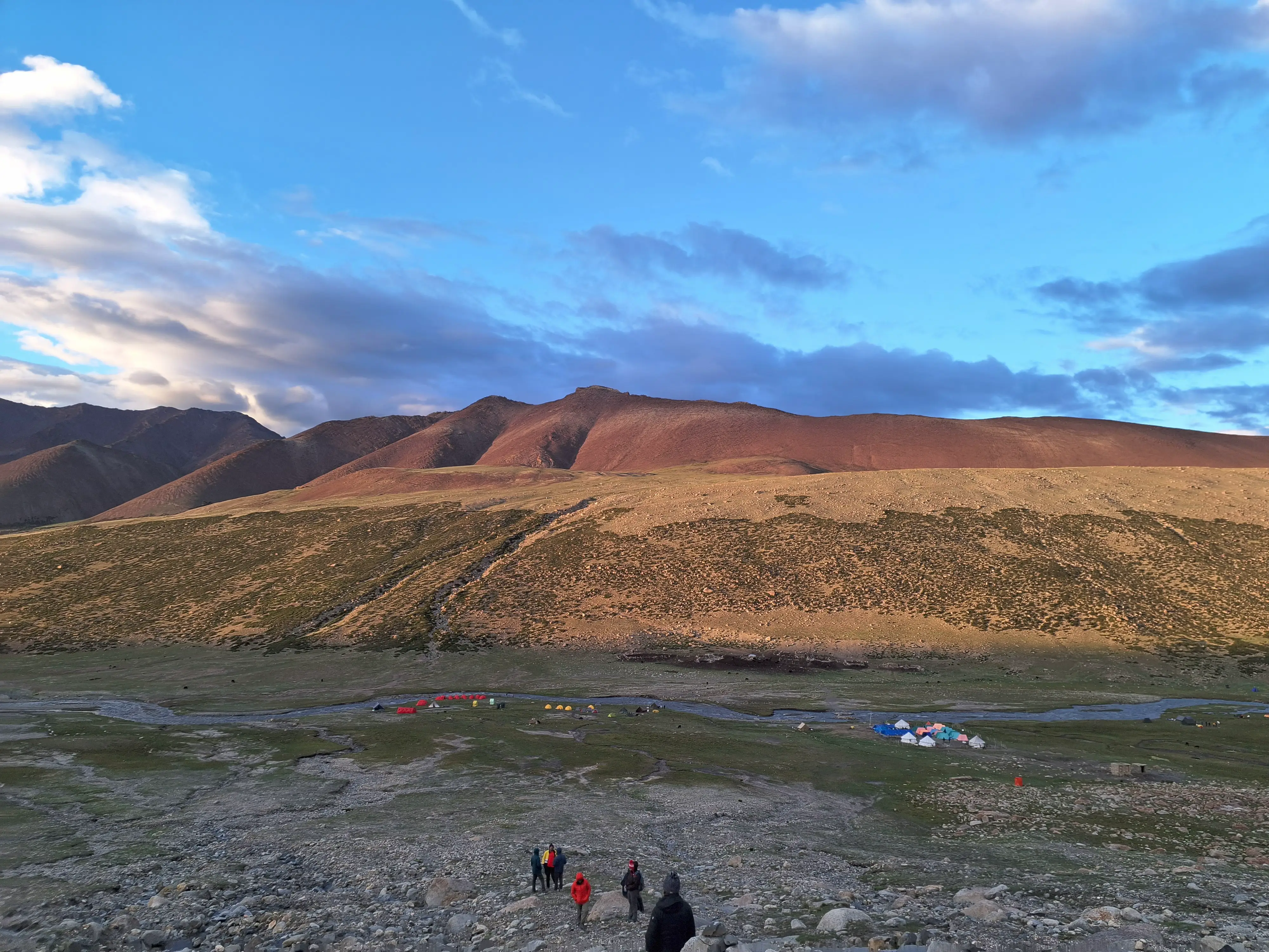 Tents scatter across a wide plain fragile marks against an ancient land. Nothing here intends to last.