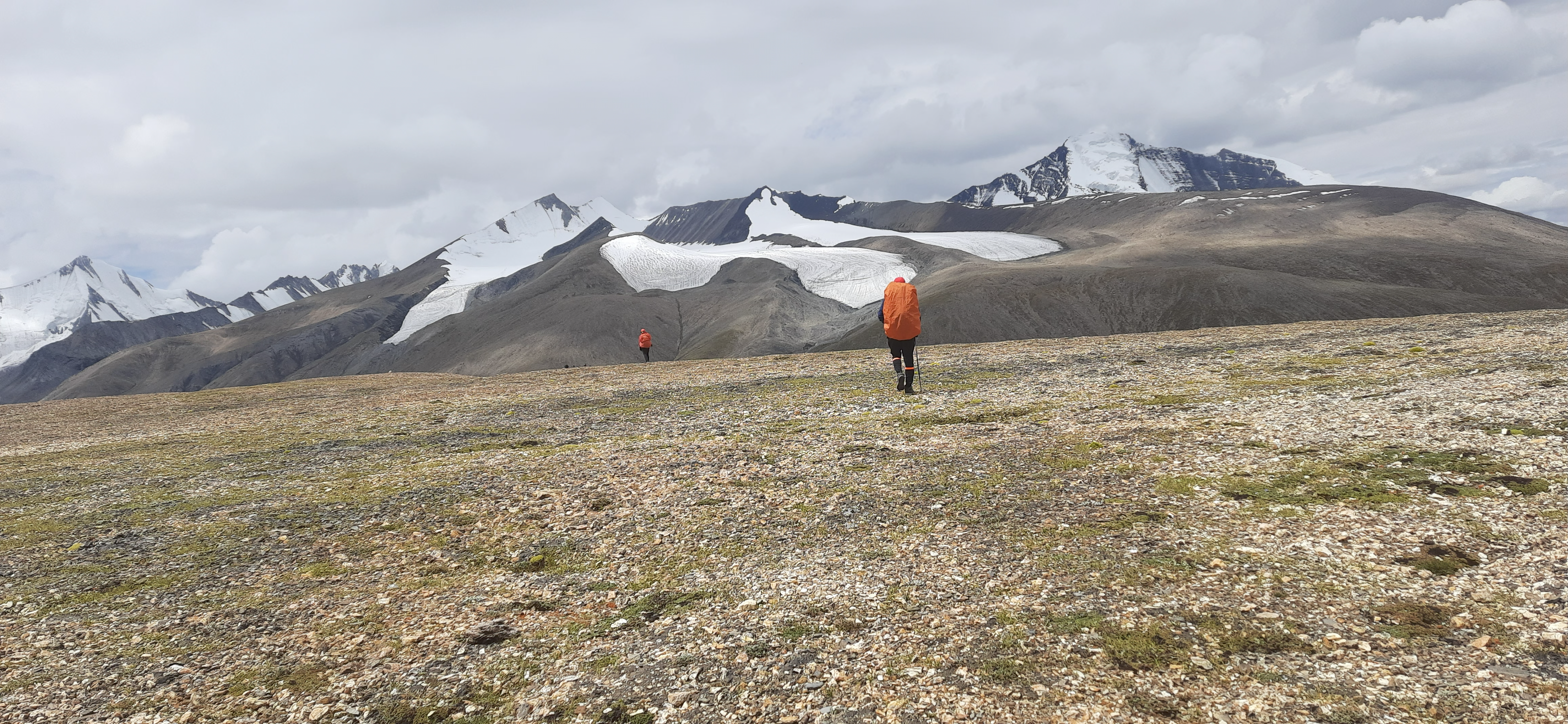 A tent at the Dzo Jongo base camp with prayer flags and the peak in the background.