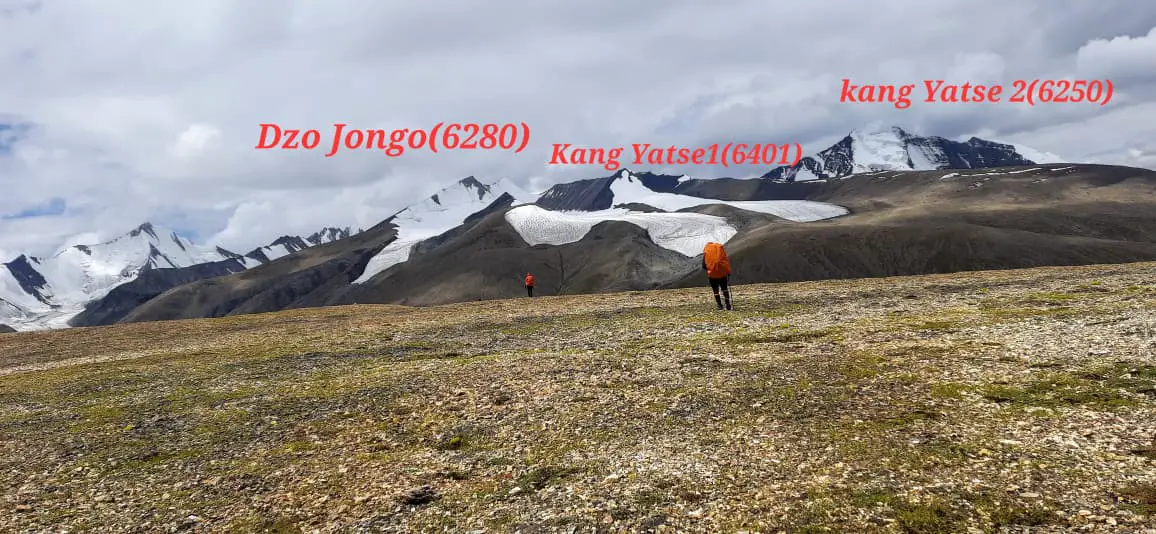 A panoramic view showcasing Dzo Jongo, Kang Yatse I, and Kang Yatse II peaks, highlighting the vastness and scale of the Ladakh mountain range.