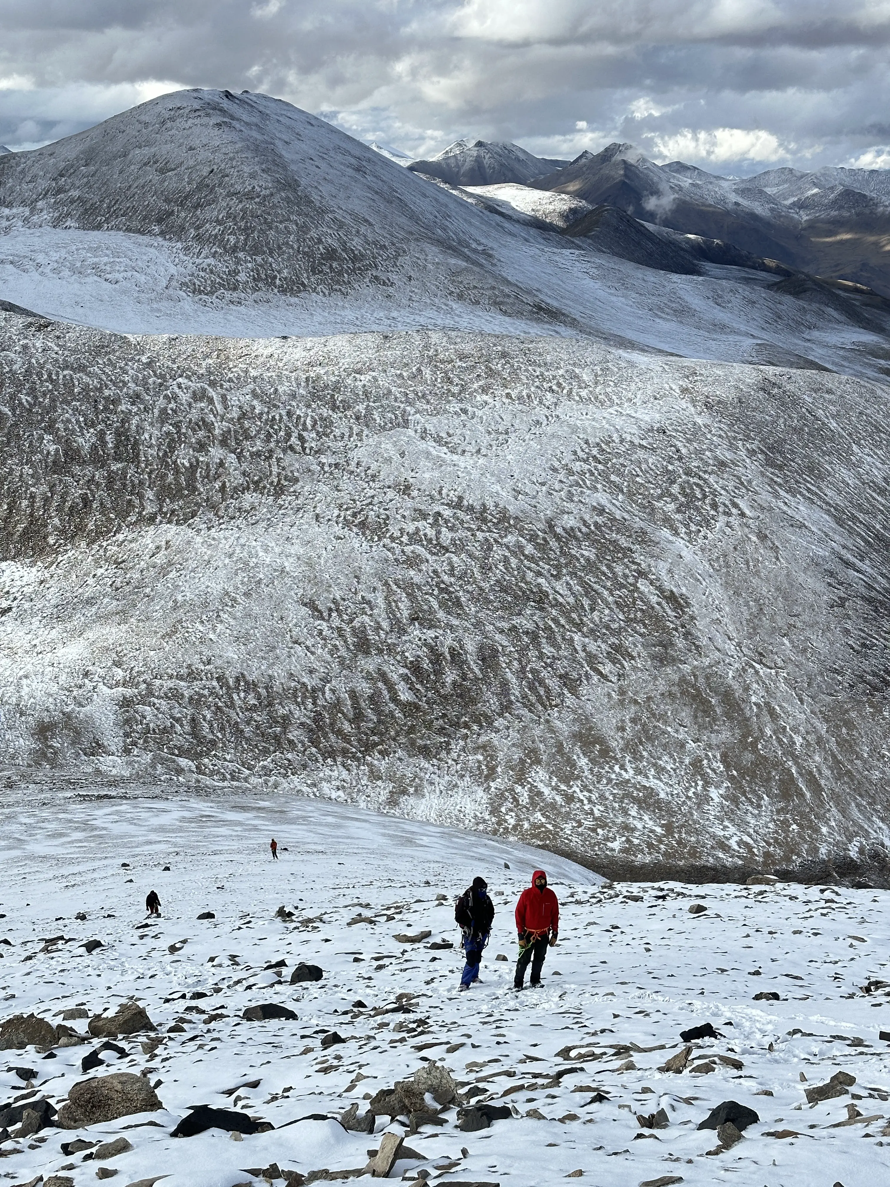 Climbers making their way up a snow-covered ridge towards the Kiagar Ri summit.