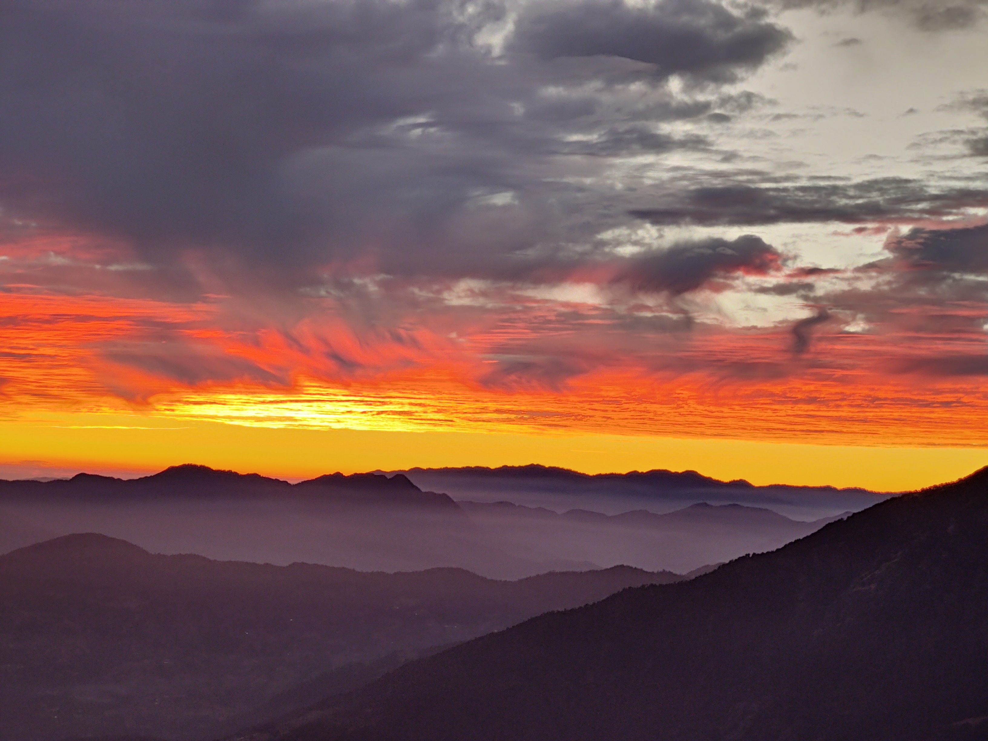 Panoramic view from the summit of brahmatal, showing the vast Himalayan landscape.