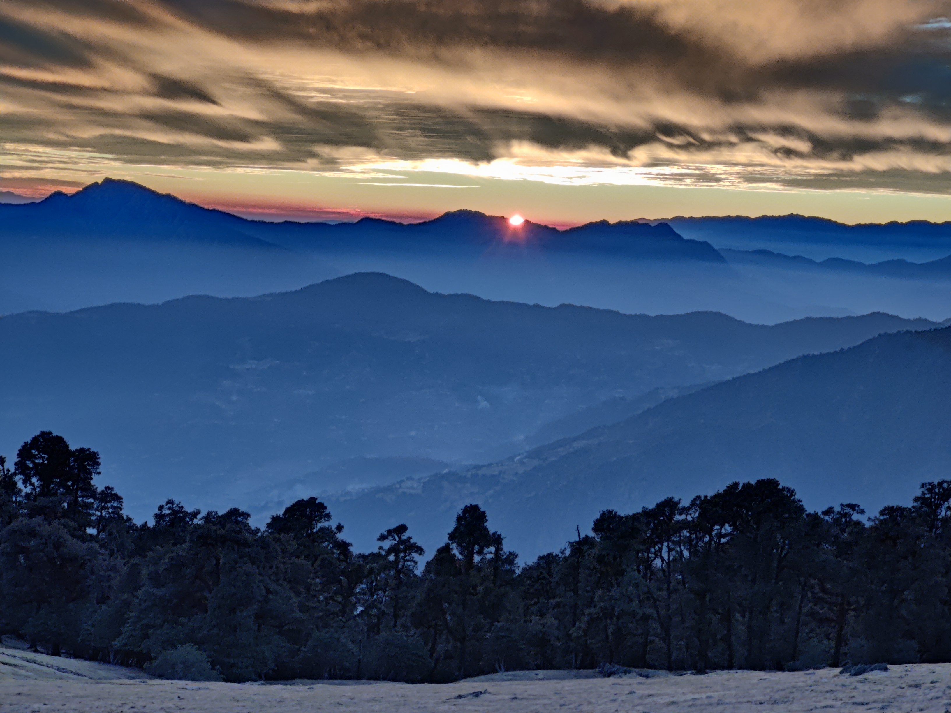 Panoramic view from the summit of brahmatal, showing the vast Himalayan landscape.