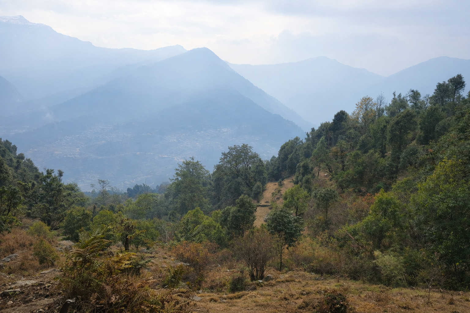 Climbers making their way up a snow-covered ridge towards the deorital summit.