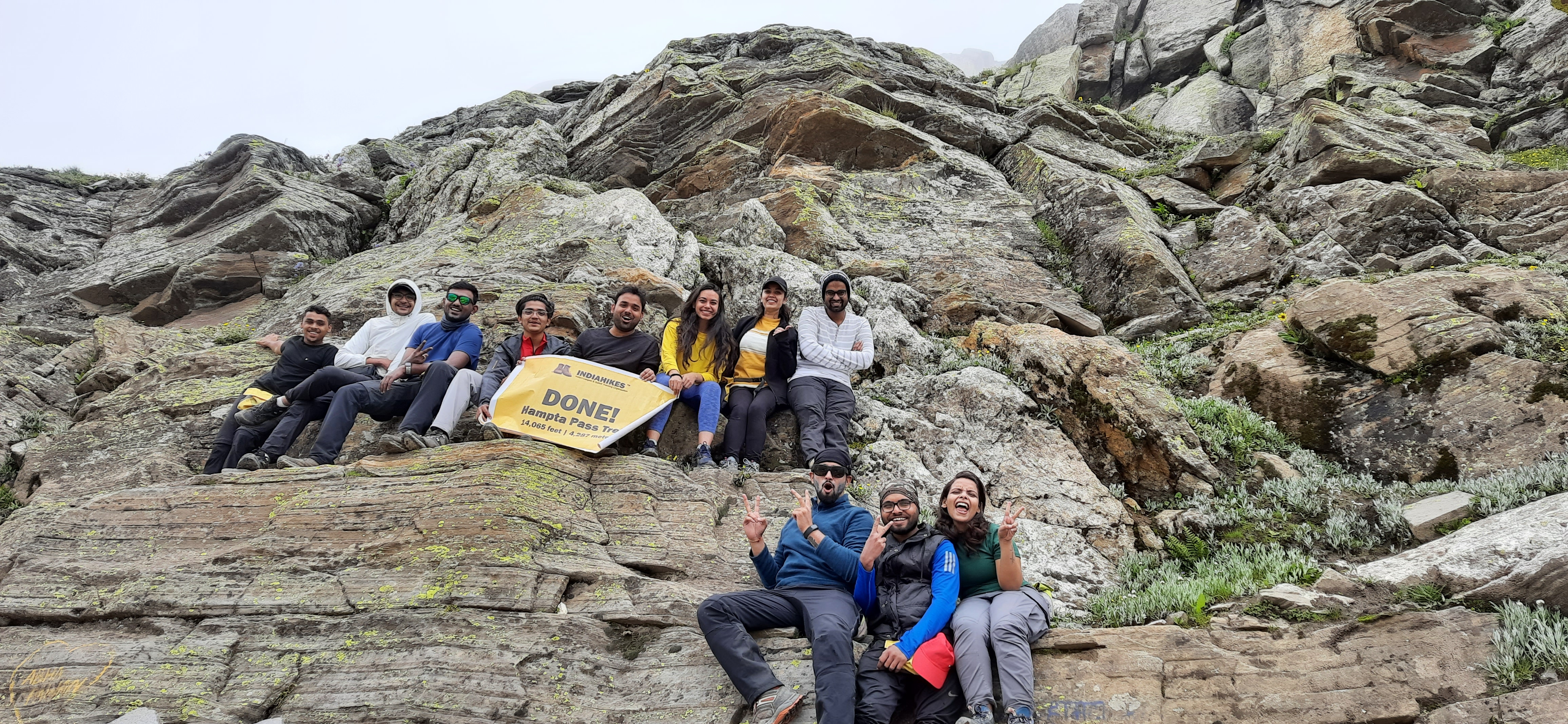 A wide shot of the hampta pass mountain range under a clear blue sky.