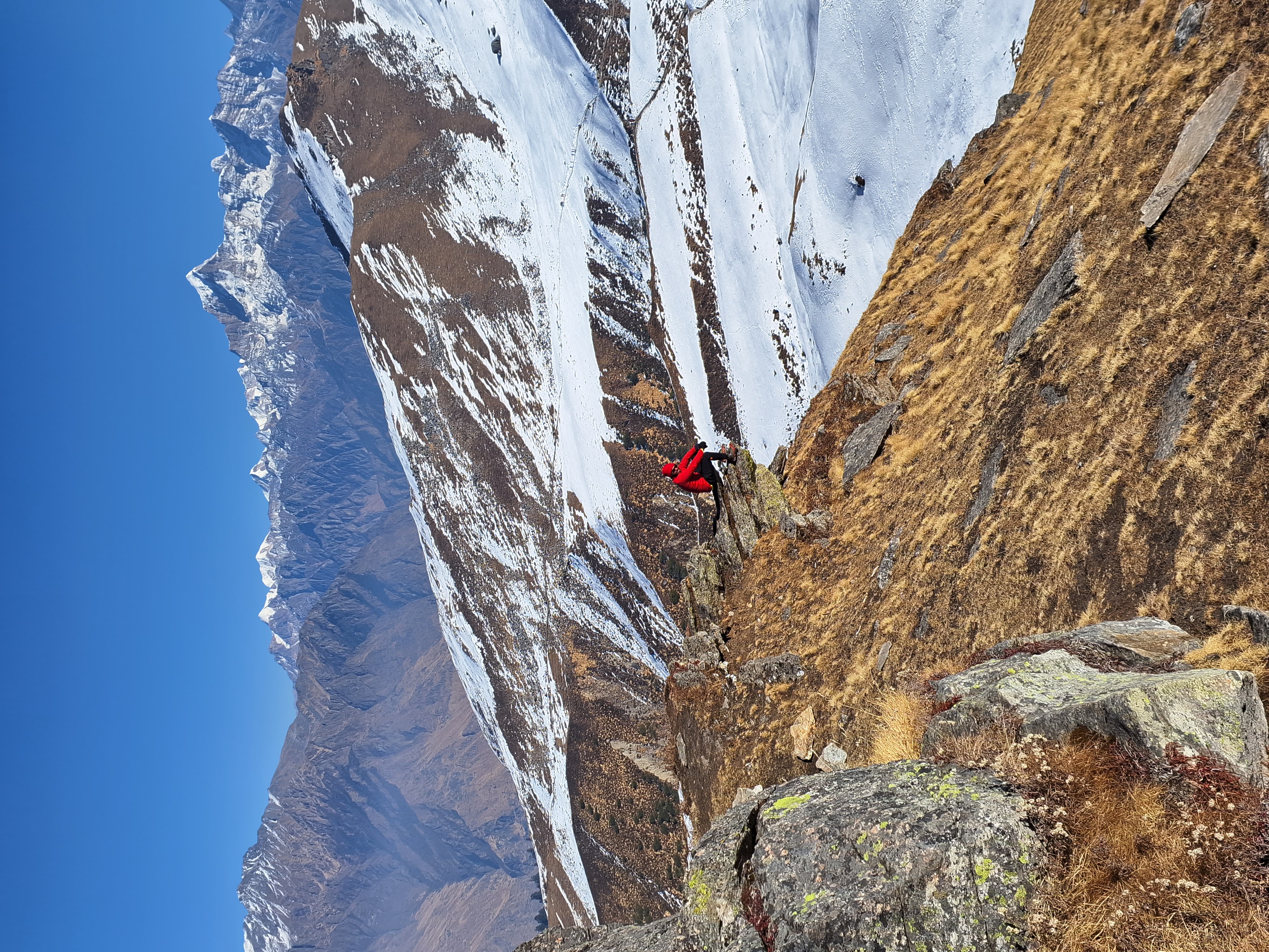 A tent at the kuari pass base camp with prayer flags and the peak in the background.