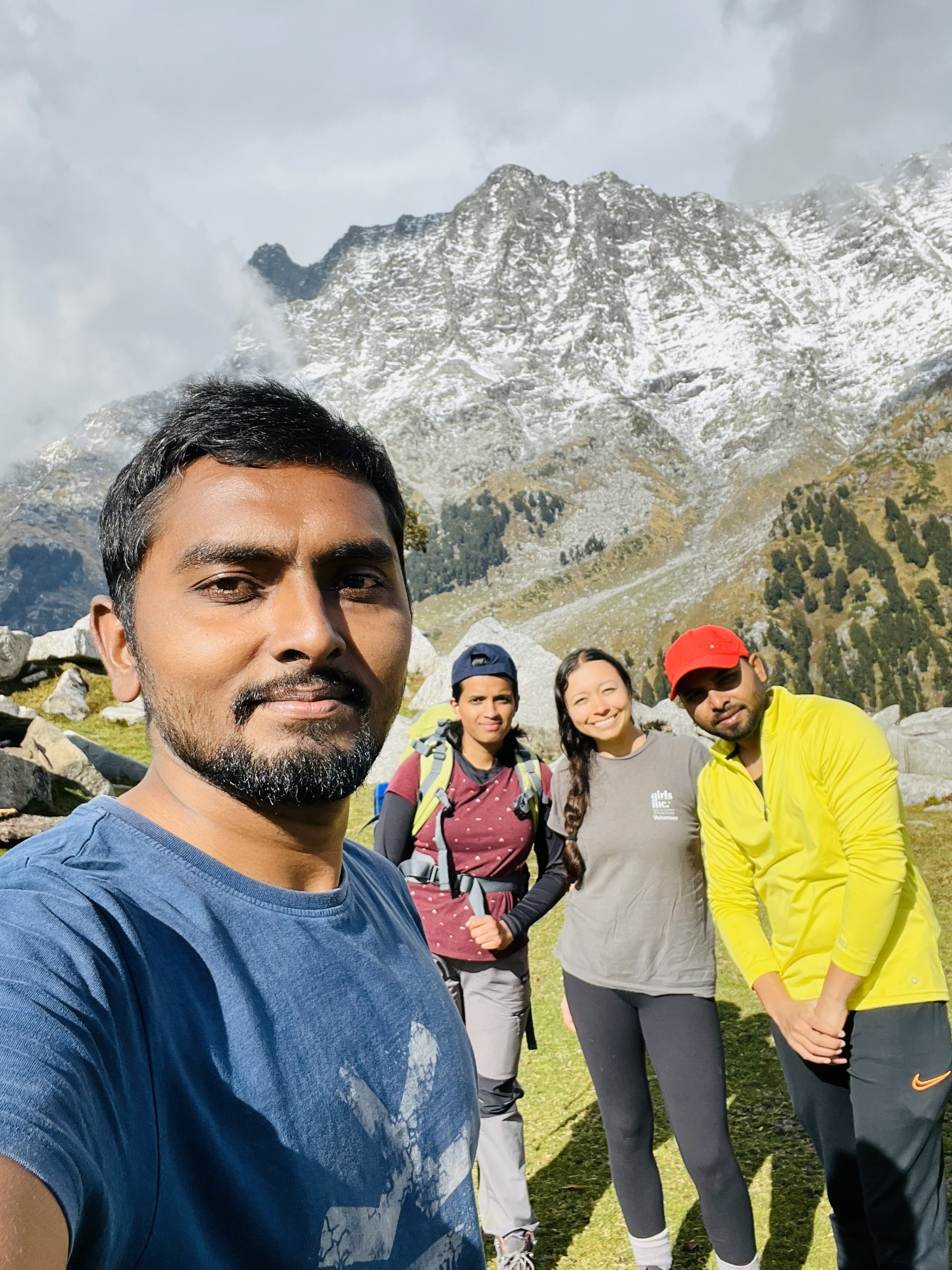 Tents pitched on the grassy meadow of Triund for night camping.