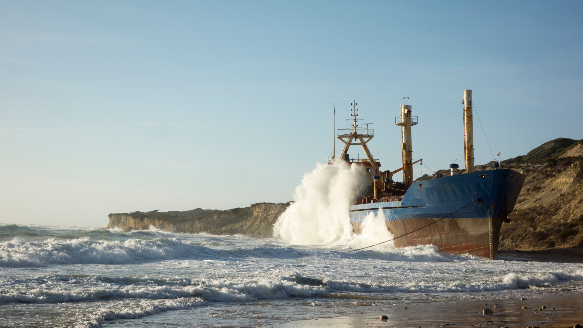 Sparks flying from a plasma cutter on a ship's hull.