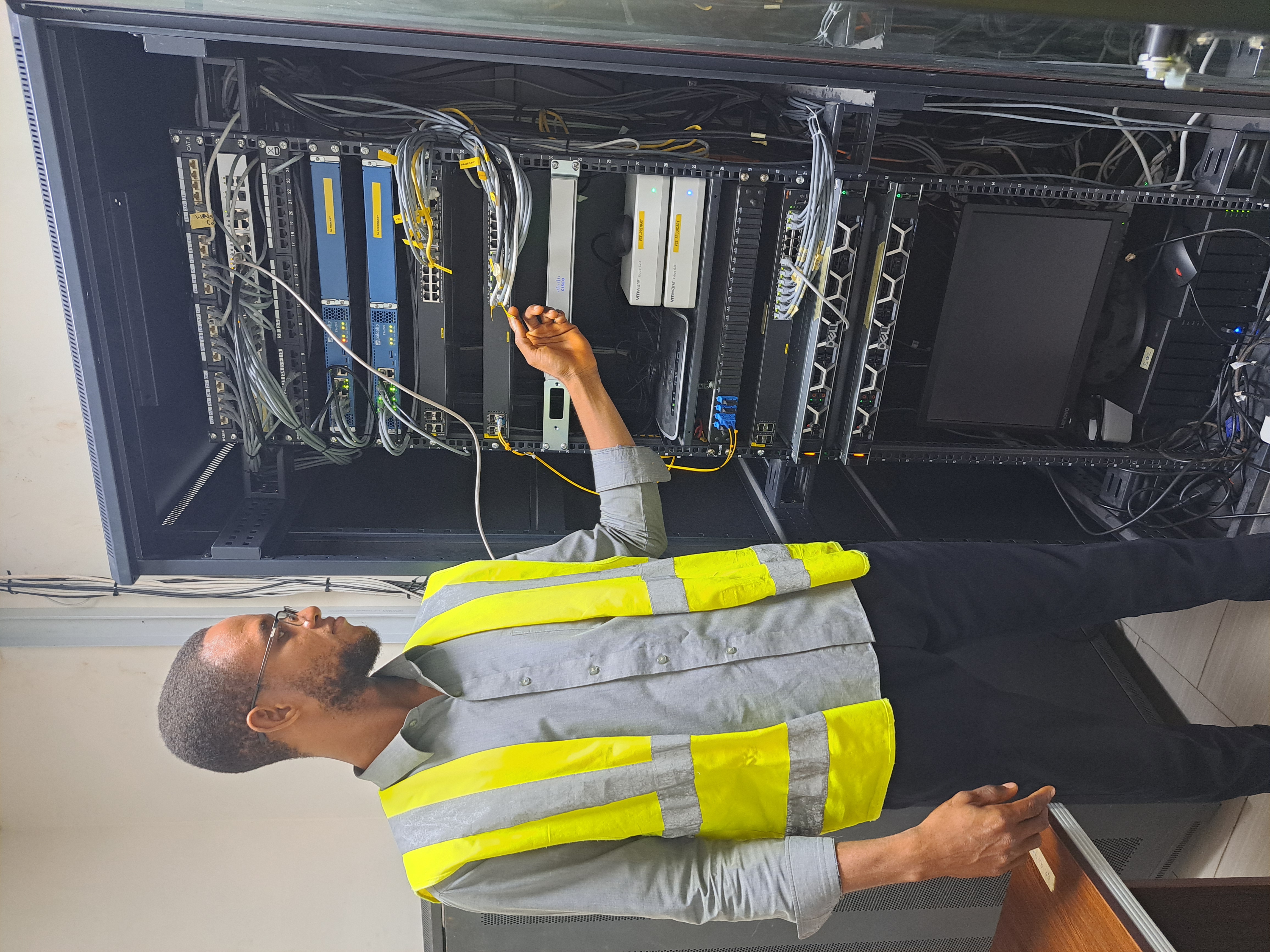 Technician working on network cables in a server rack.
