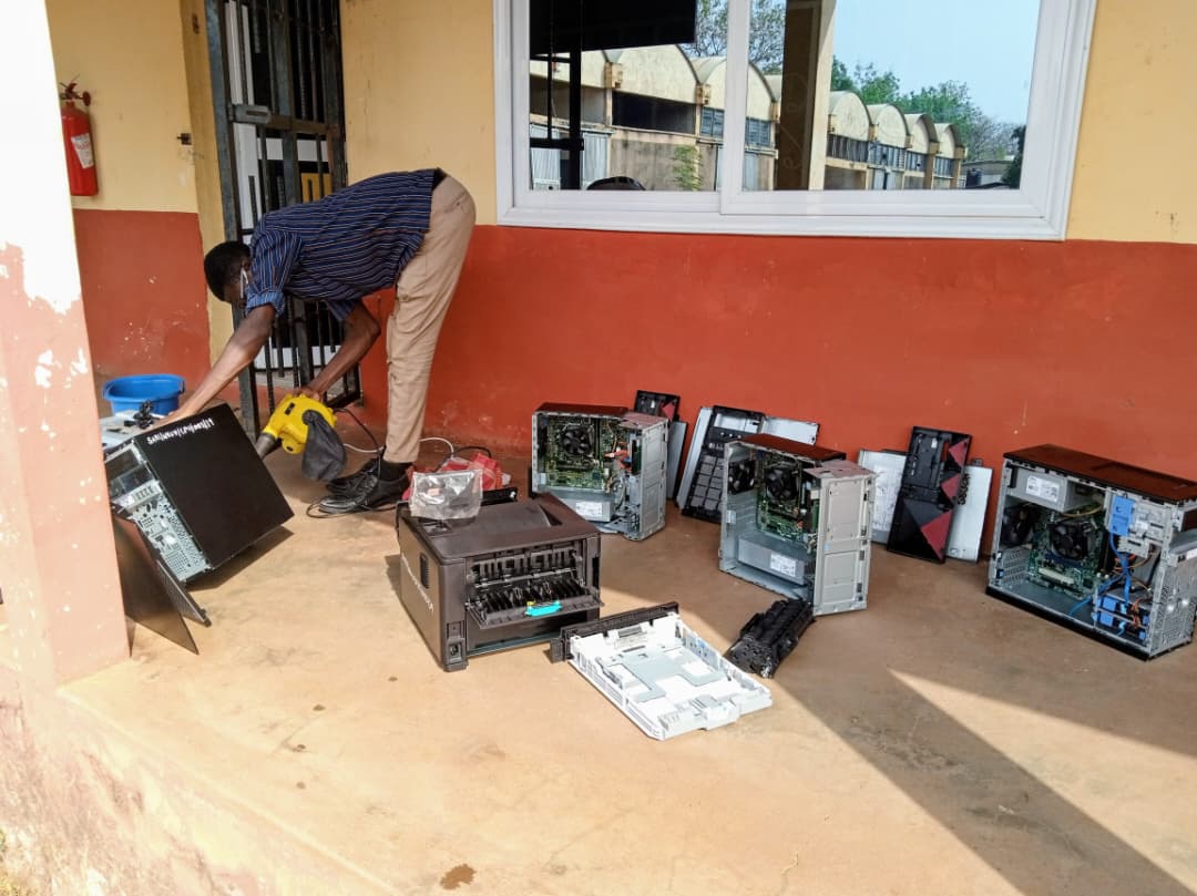 An engineer performing hardware diagnostics and repairs on several PCs.