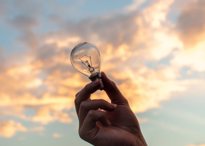 Símbolos de inovação e integridade, como uma lâmpada e um aperto de mãos.