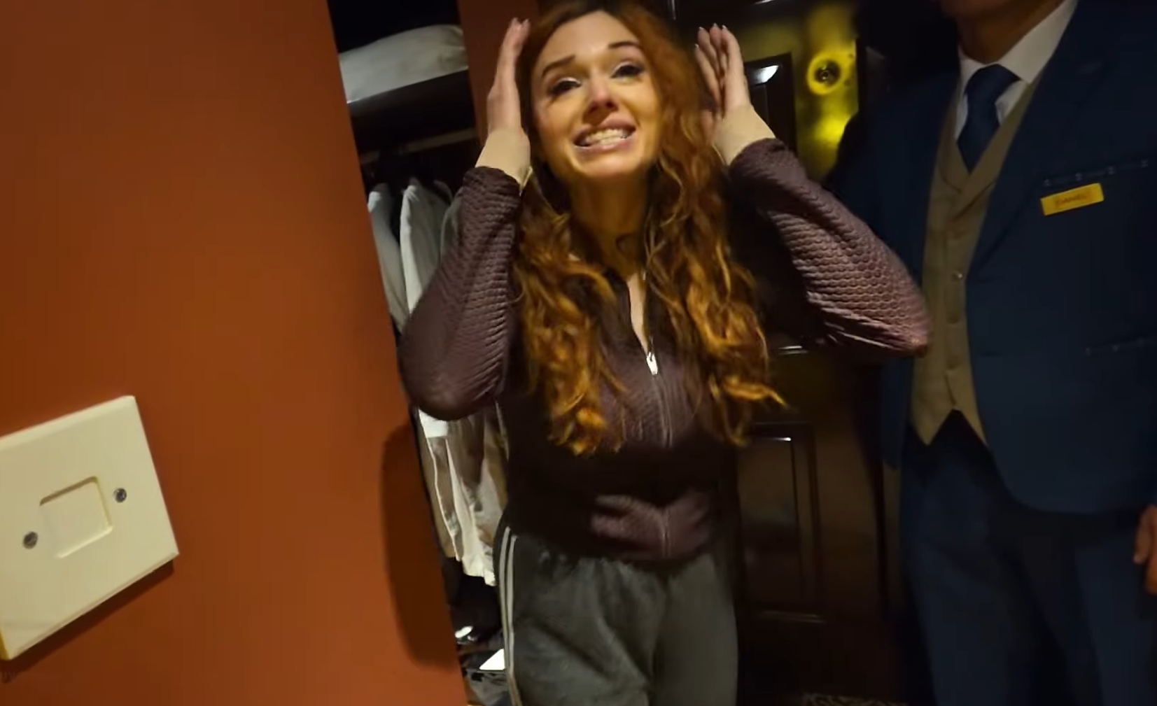 Amouranth looking stressed in a hotel room.