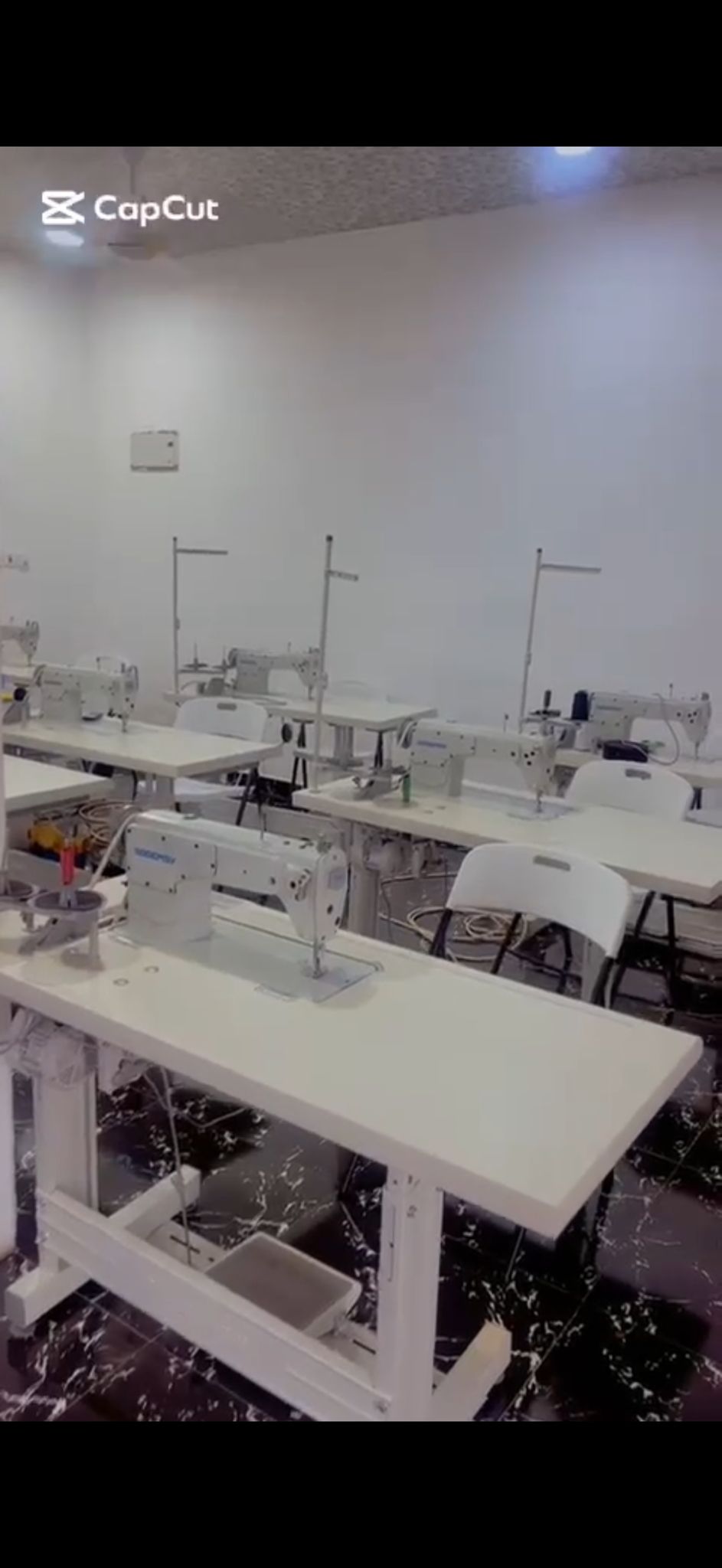 Sewing machines lined up in a workshop.