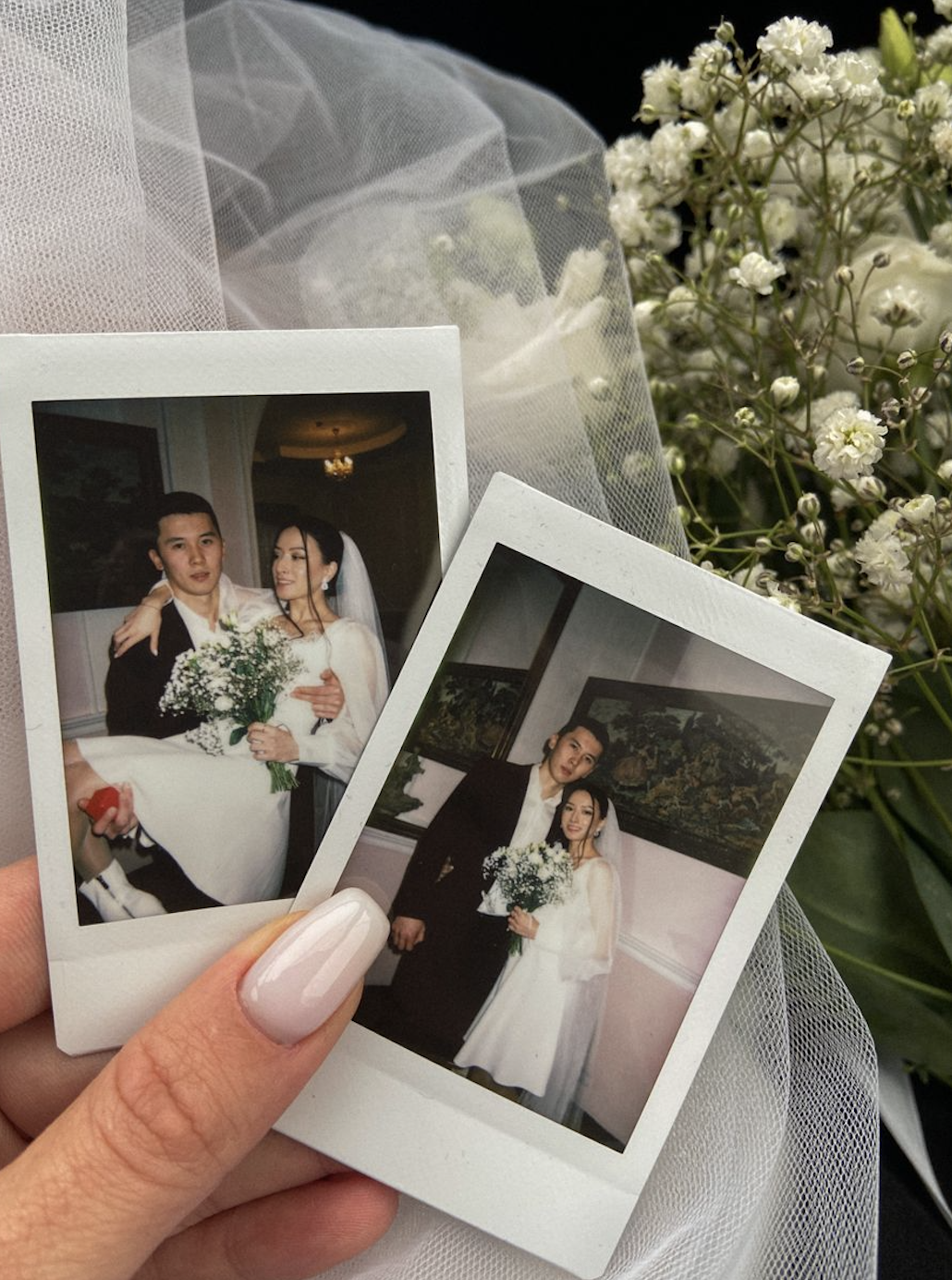 Couple holding polaroids.