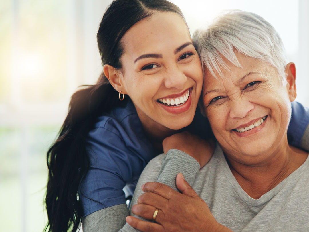 Happy woman, nurse and hug senior patient in elderly care, support or trust at old age home. Portrait of mature female person, doctor or medical caregiver hugging with smile for embrace at house.