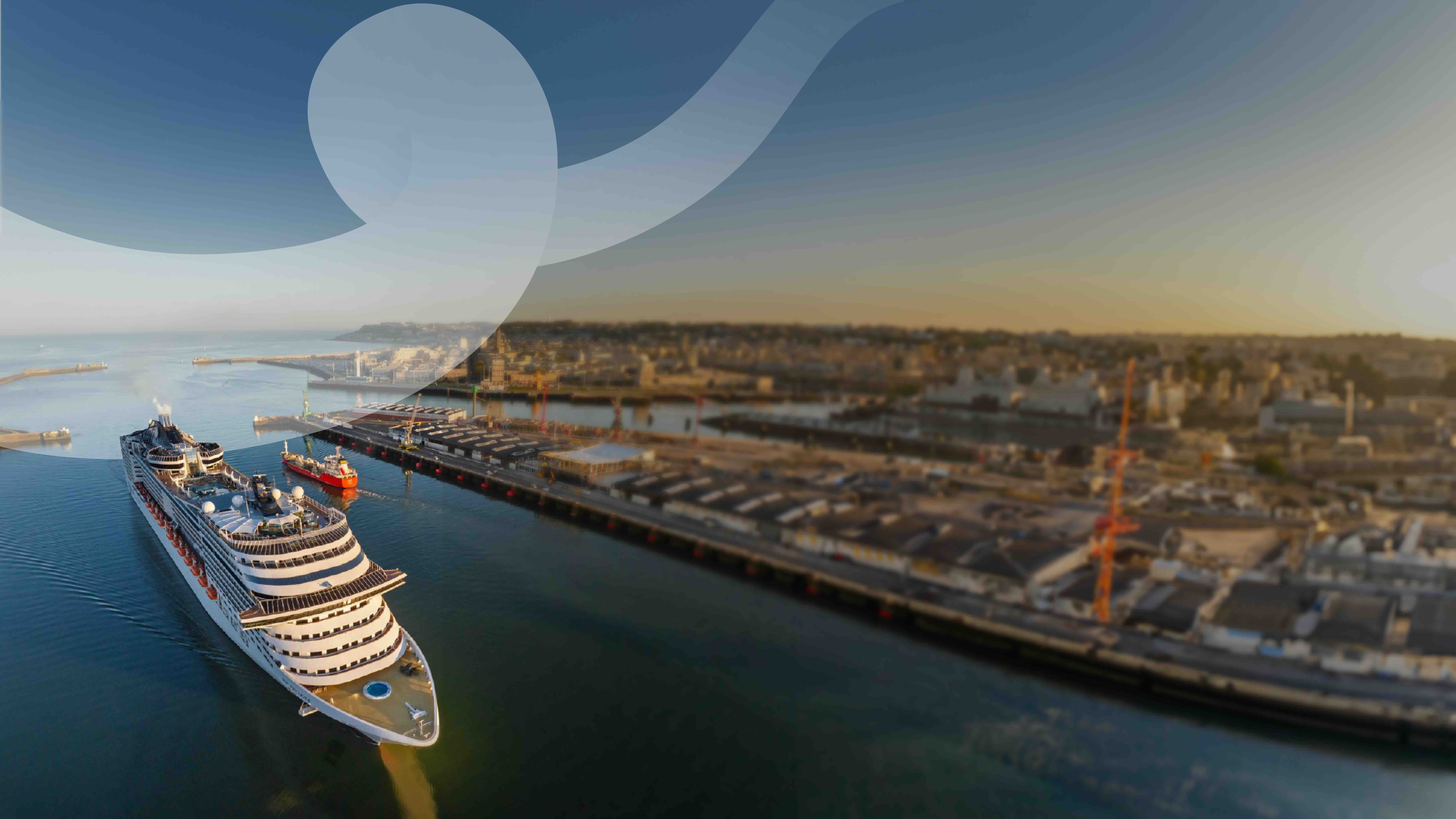 A large cruise ferry docked in a modern port at sunset.