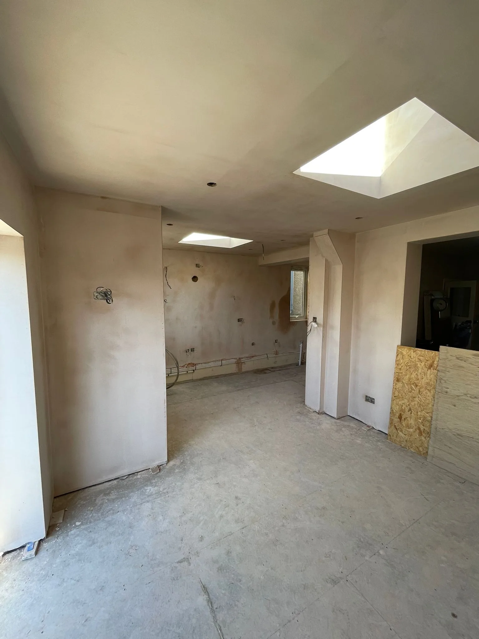 Plastered single-storey extension in Kingswood with two rooflights and a bare floor