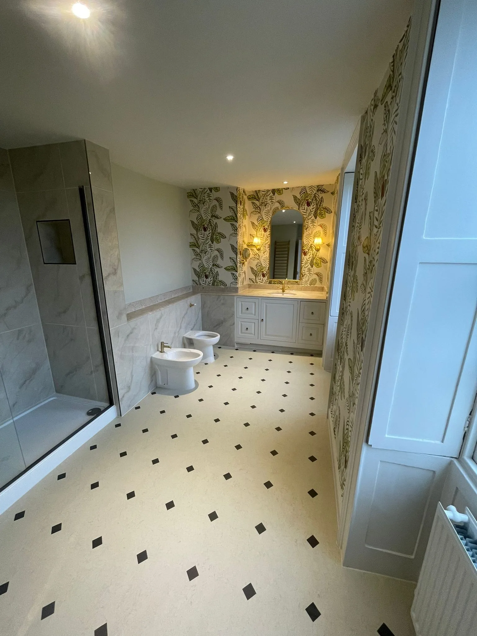 Georgian en-suite with walk-in shower, vanity, leaf wallpaper, black-and-white floor and window shutters