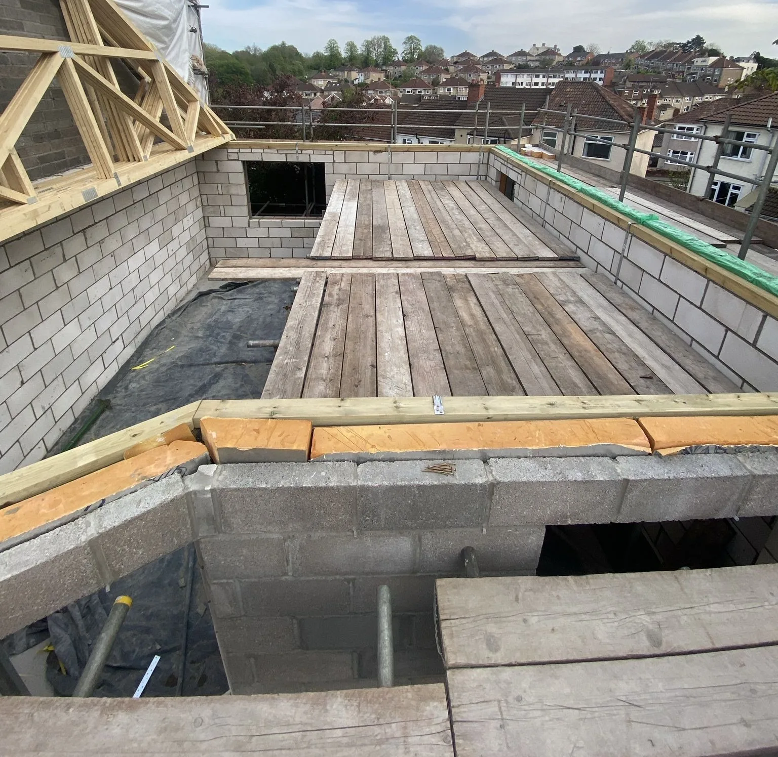 First-floor blockwork walls and deck seen from the scaffold, with Brislington rooftops behind