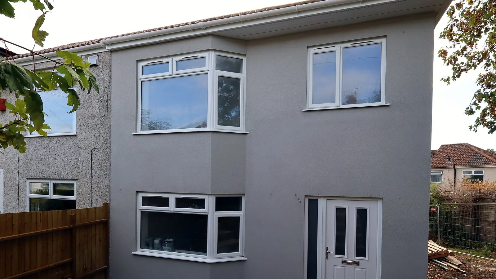 New build house in Bristol: the finished bay-fronted front of the Sherwell Road house in Brislington, grey render, white door