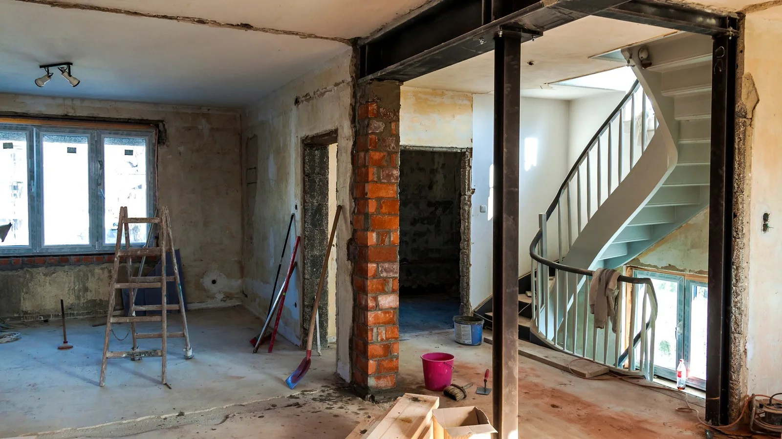 Removing a load bearing wall: a house mid-renovation with a new steel beam and props where walls have come out