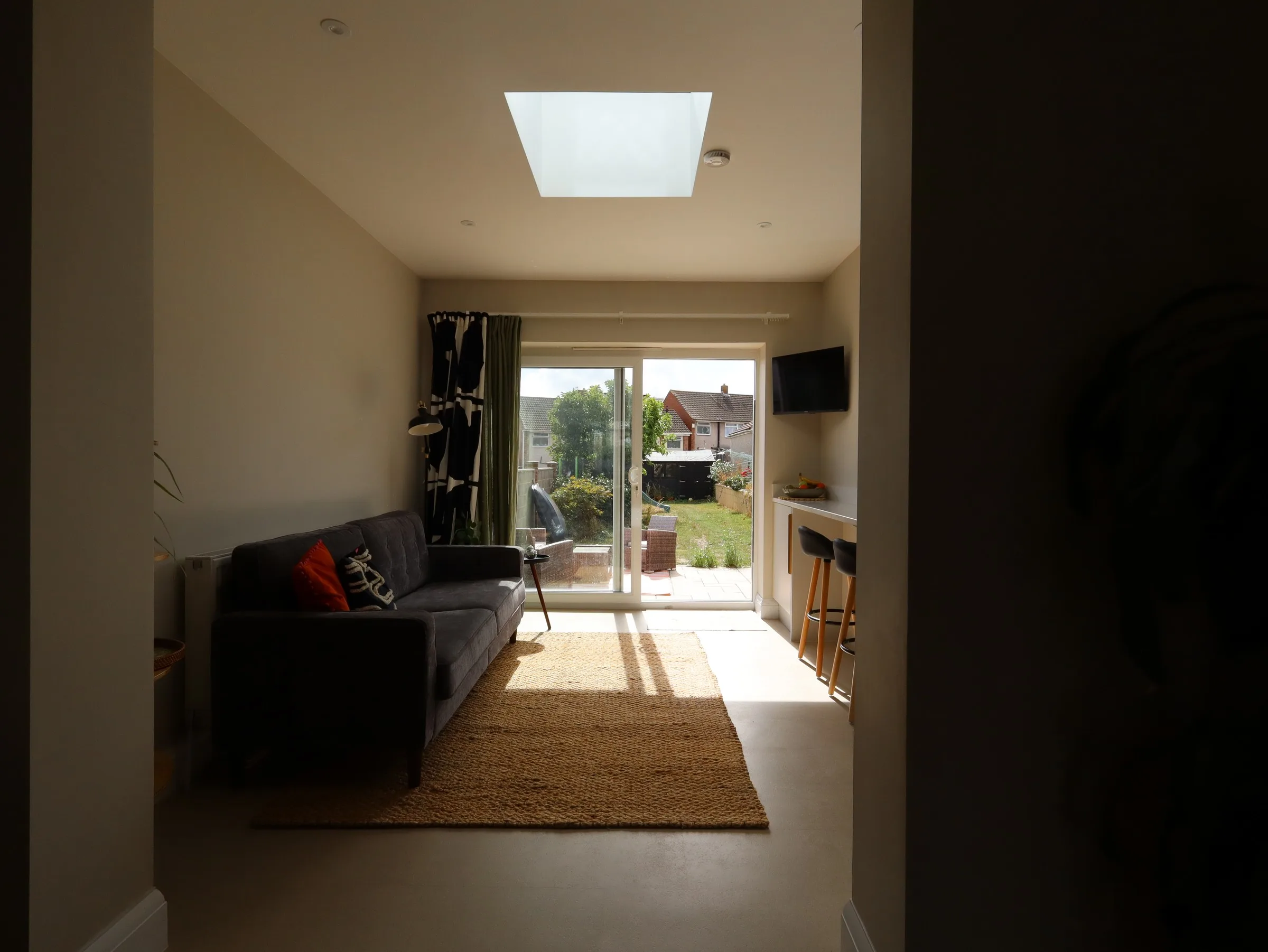 Living area under a large rooflight in a Kingswood rear extension, with sliding doors to the garden