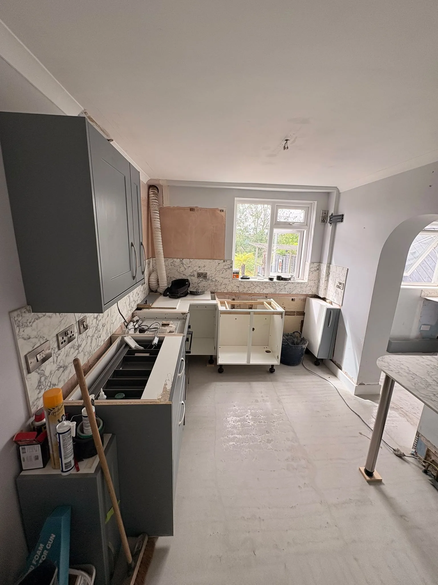 Grey shaker kitchen units being refitted on a new smooth floor
