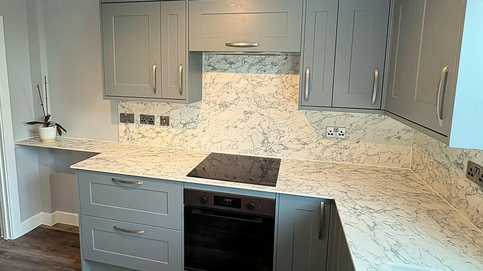 Grey shaker kitchen with marble-effect worktops, reinstated on a new floor after subsidence repairs