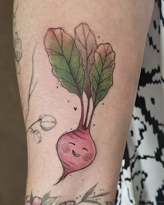 Kolorowy tatuaż uśmiechniętego buraka na nodze, w stylu ilustracyjnym.