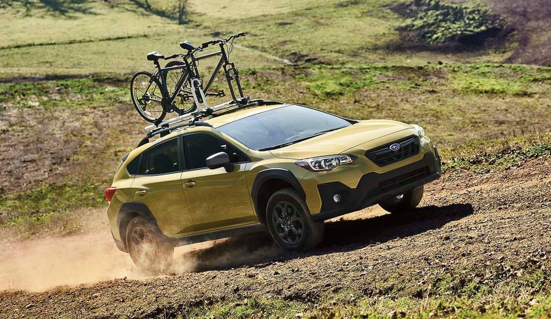 Un VUS Subaru Crosstrek 2022 roulant sur un chemin hors-route incluant sa garde au sol élevée