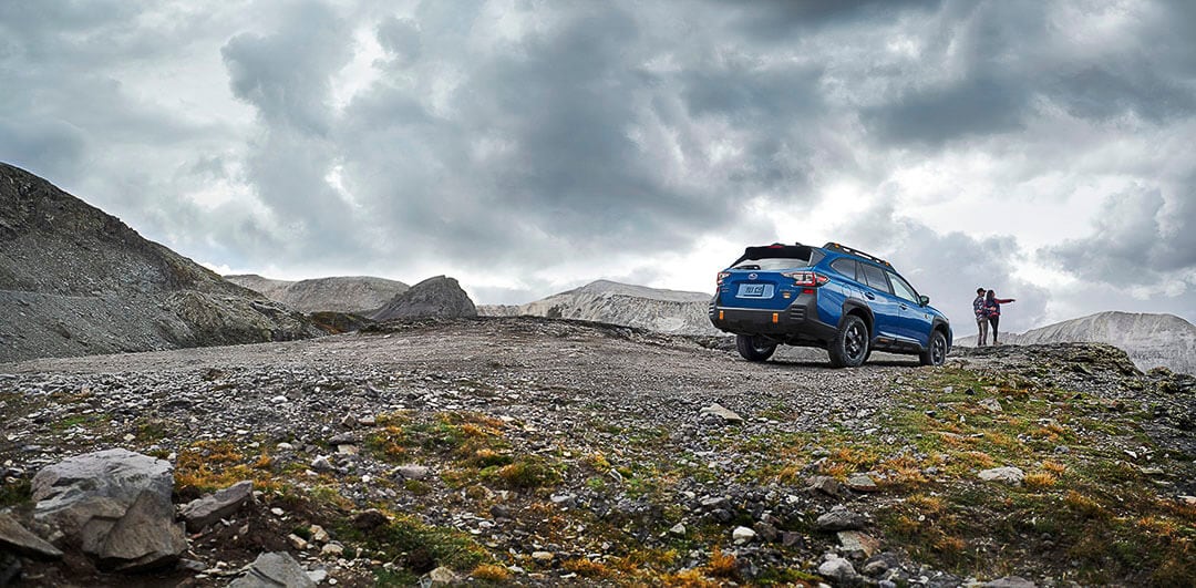 vue 3/4 arrière d'un Subaru Outback Wilderness 2022 sur une terre de rochers en nature