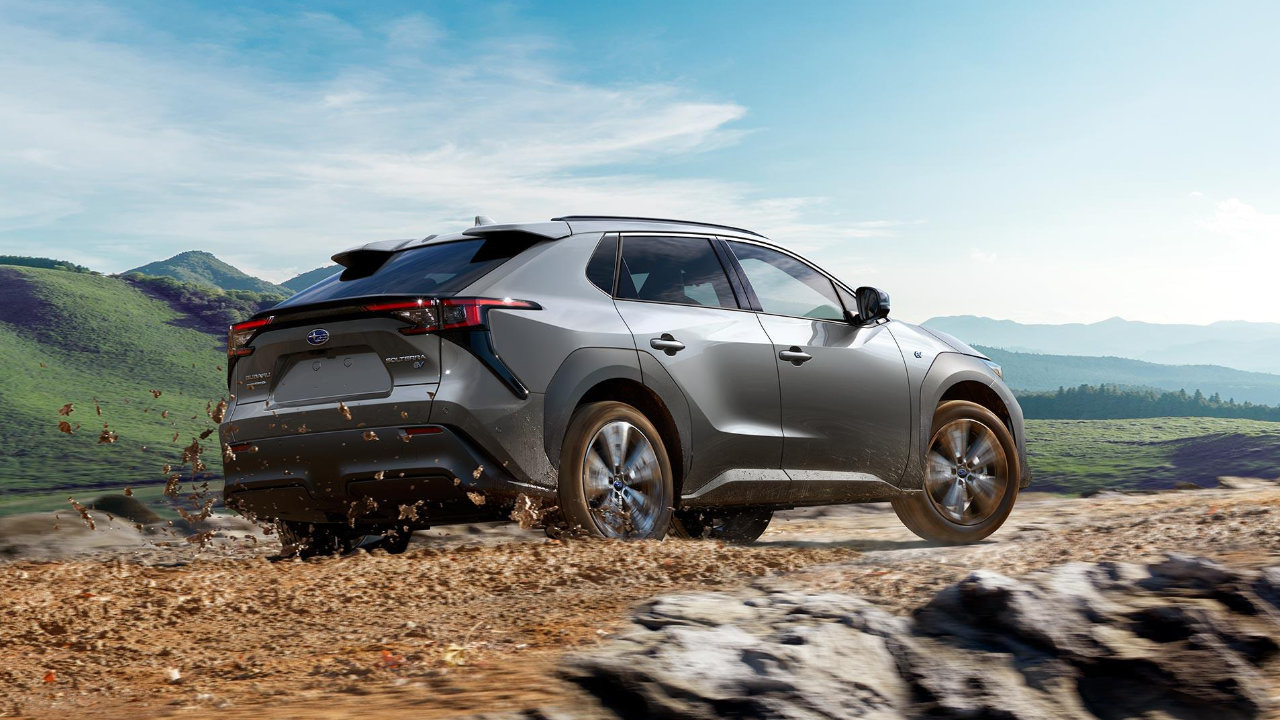 vue latérale arrière d'une Subaru Solterra 2023 qui traverse un sentier boueux