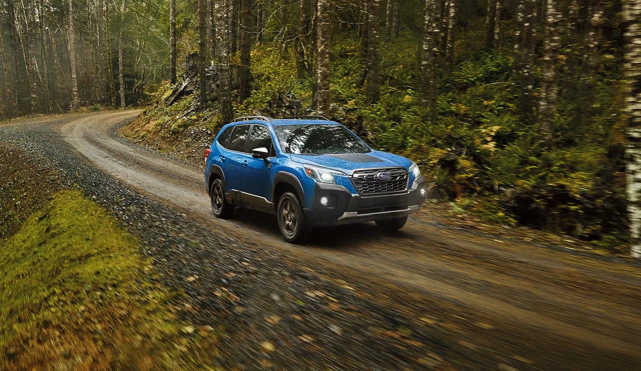 Vue 3/4 avant du Subaru Wilderness 2023 roulant sur un sentier forestier.