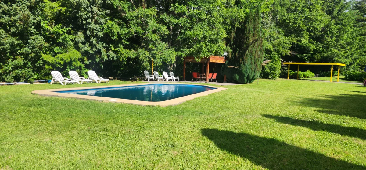 Piscina al aire libre rodeada de naturaleza en Instalación del recinto, ideal para relajarse y disfrutar del verano.