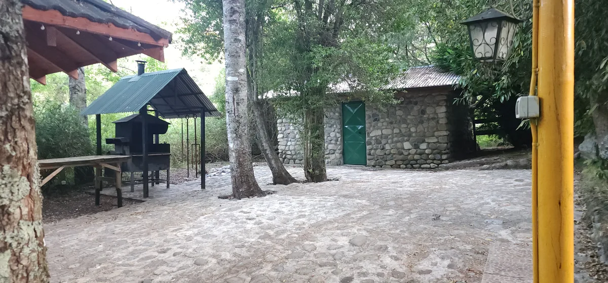 Instalación de recinto con parrilla, mesa y cabaña de piedra en área común de Prueba 1.