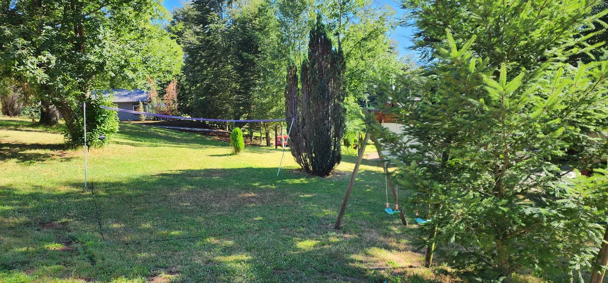 Instalación del recinto Prueba 1: área común con red de voleibol y columpio. Ideal para familias y diversión al aire libre.