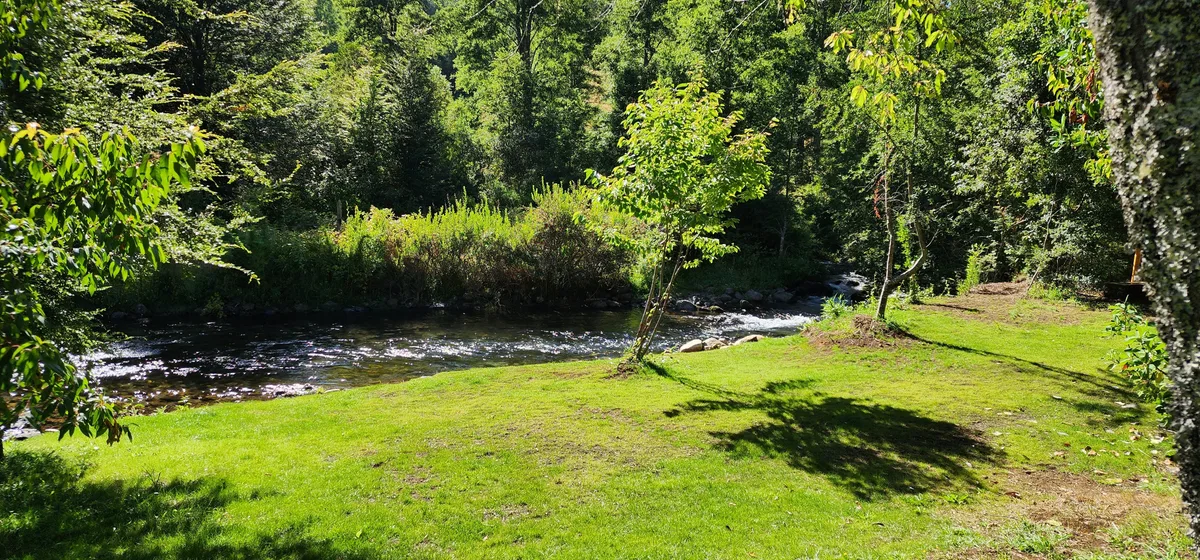 Instalación del recinto con río y vegetación exuberante. Ideal para relajarse en la naturaleza.