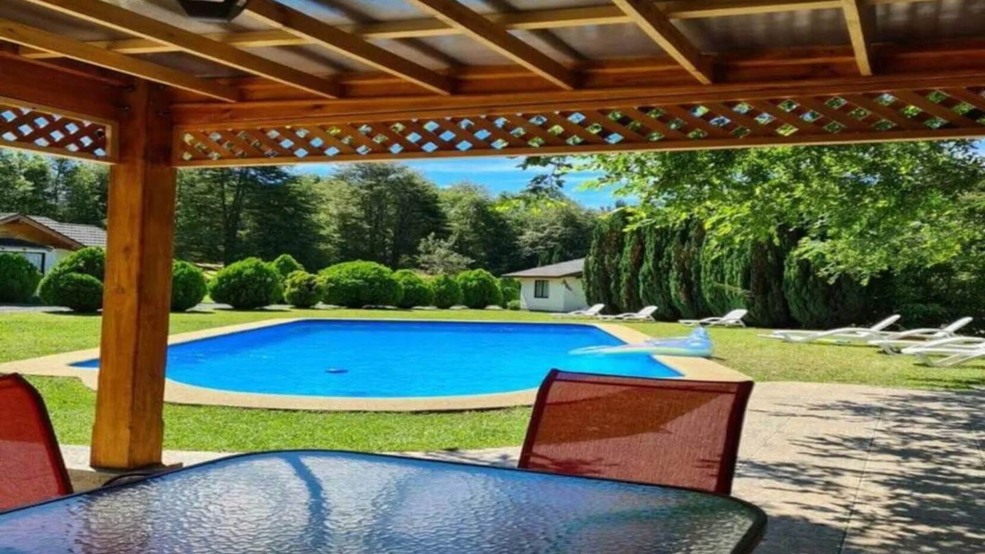 Familia disfrutando tinaja privada de agua caliente con vista al Río Coilaco en complejo turístico Pucón.