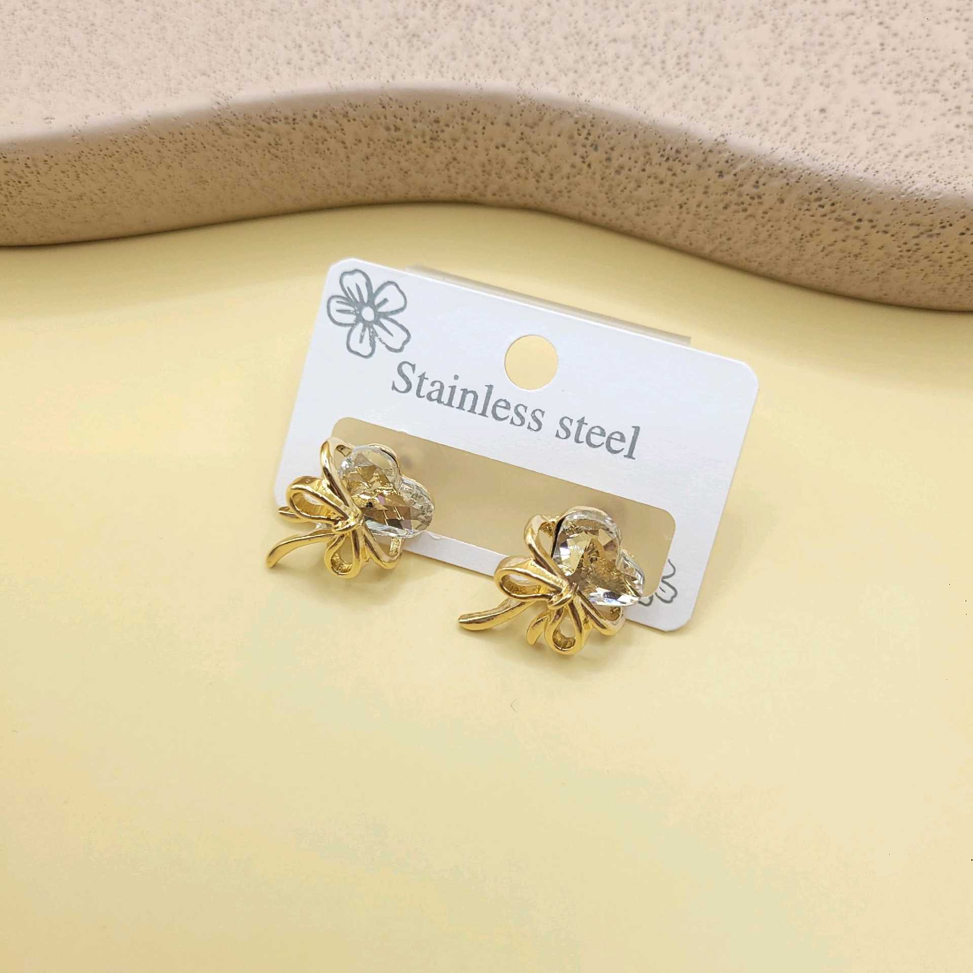 Aretes moño y corazón transparente / chapa