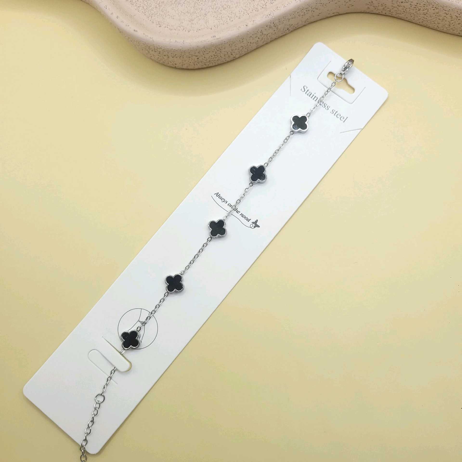 Pulsera  Van cleef negra dijes pequeños tono plata/ acero inoxidable 