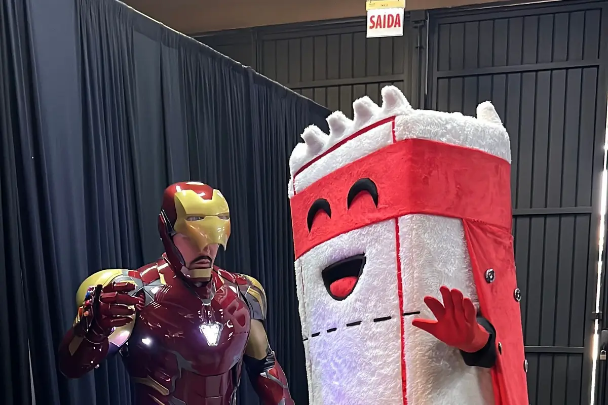 Cosplayer de Homem de Ferro com armadura iluminada ao lado do Ticão