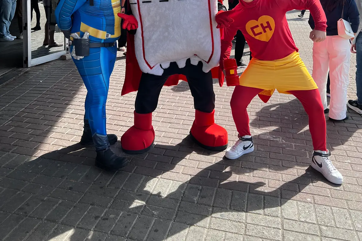 Dois cosplayers se divertindo com o Ticão na entrada de uma convenção