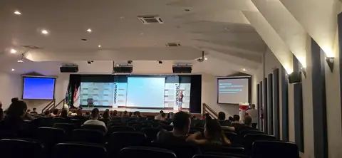 Auditório lotado assistindo a uma palestra