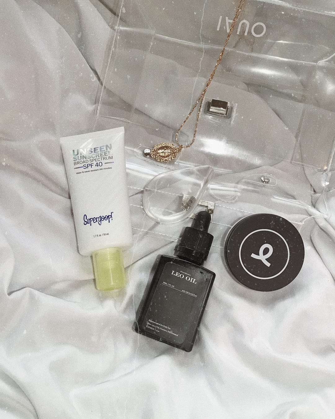 Three skincare products laid flat on a white sheet.