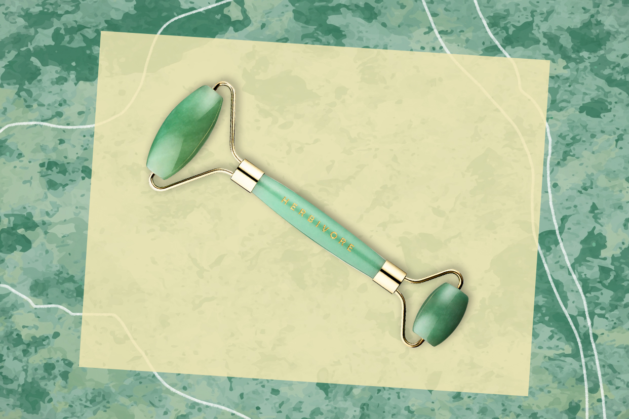 A jade roller on a marbled background