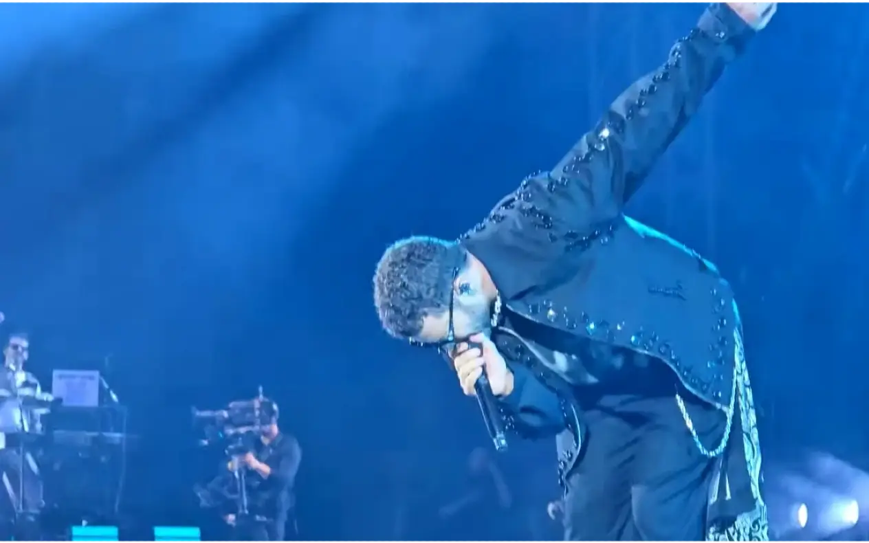 Justin Timberlake sa kratkom bradom i kratkom kosom, obučen u crno odelo peva na koncertu u Beču