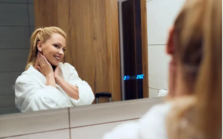 Nasmejana žena se gleda u ogledalo