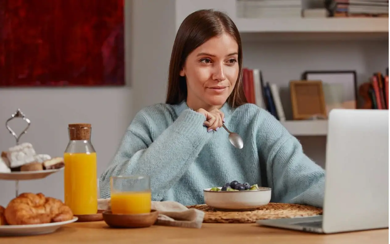 Devojka za računarom Devojka za računarom sedi i jede