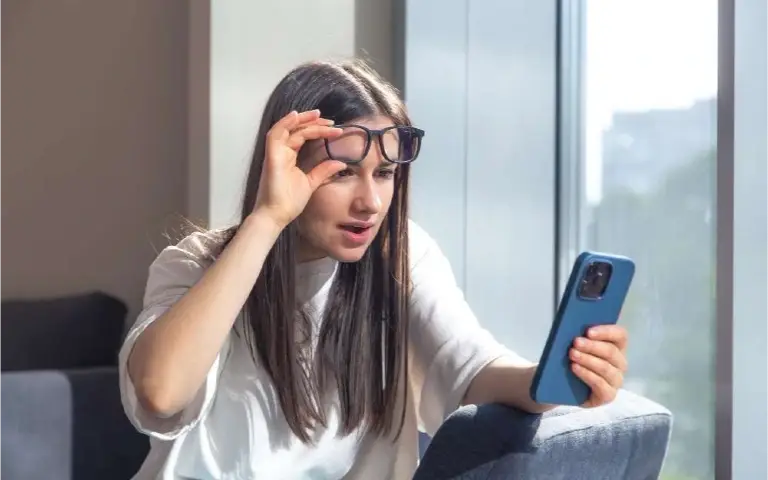 Devojka sa telefonom Devojka iznenađena gleda u telefon