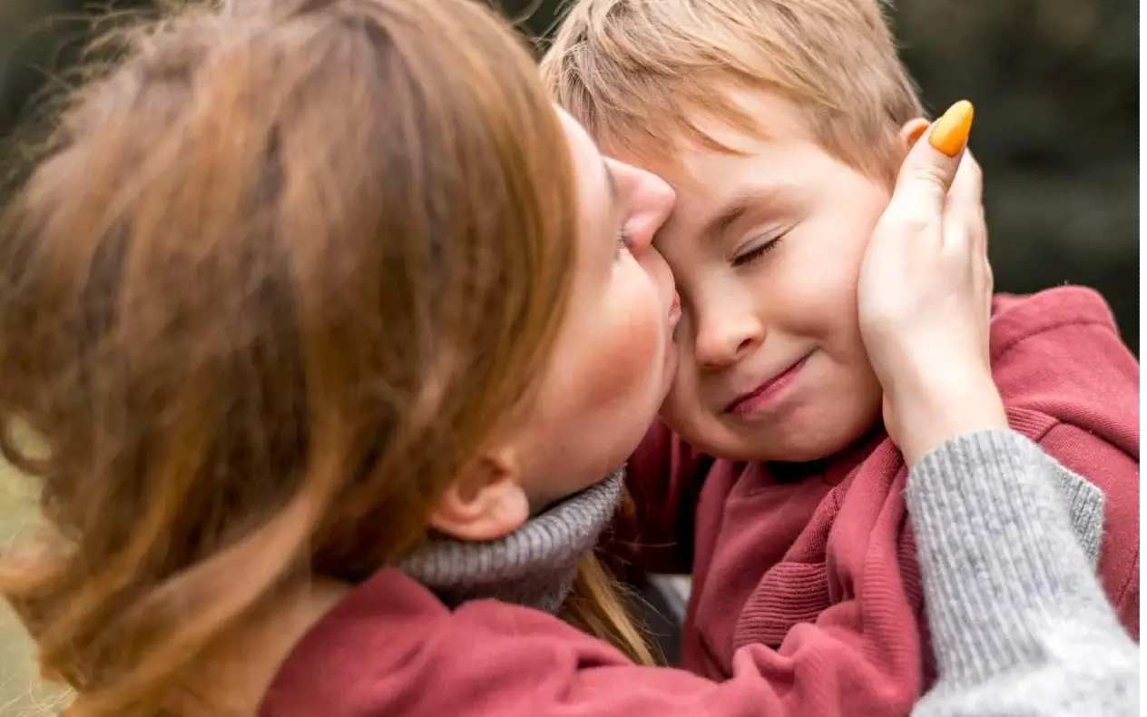 Žena i dete Žena grli dete nakon emotivnog ponovnog susreta sa osobom koja mu je spasla život